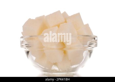 Qualche cubetto di zucchero bianco in una ciotola di vetro, macro, isolata su fondo bianco. Foto Stock