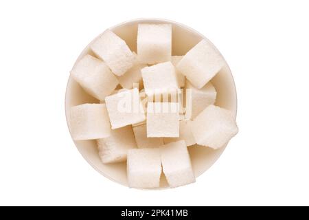 Diversi cubetti di zucchero bianco con un piattino di ceramica bianco su sfondo bianco, macro, vista dall'alto. Foto Stock