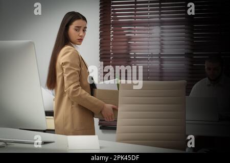 Sconvolto donna licenziato scatola di trasporto con personale roba in ufficio Foto Stock