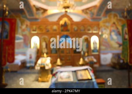 Vista offuscata del bellissimo interno della chiesa con icone ecclesiastiche Foto Stock