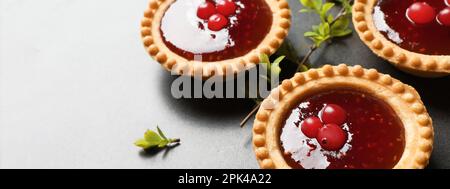 Gustose tartine con marmellata sul tavolo grigio, vista primo piano con spazio per il testo. Design del banner Foto Stock