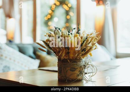 Gambi di grano secco in vaso di vetro trasparente su sfondo bianco. Spikelets di grano. Immagine per design e interioir. Foto Stock