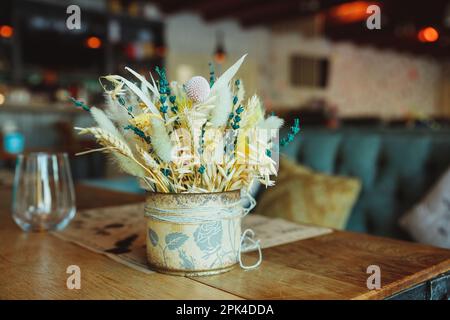 Gambi di grano secco in vaso di vetro trasparente su sfondo bianco. Spikelets di grano. Immagine per design e interioir. Foto Stock