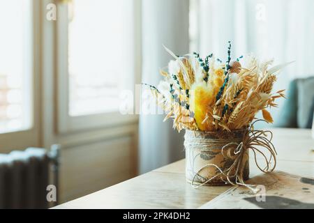 Gambi di grano secco in vaso di vetro trasparente su sfondo bianco. Spikelets di grano. Immagine per design e interioir. Foto Stock