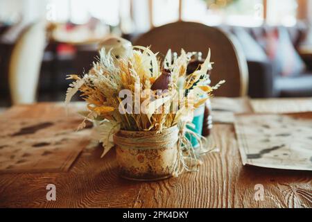 Gambi di grano secco in vaso di vetro trasparente su sfondo bianco. Spikelets di grano. Immagine per design e interioir. Foto Stock