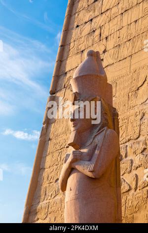 Il pilone di Ramesses ll con uno dei Colossi, Luxor Tempio, Luxor, Egitto, Nord Est Africa Foto Stock
