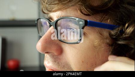 Giovane freelance con occhiali che lavorano a casa Foto Stock