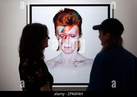 Londra, Regno Unito. 5 aprile 2023. I visitatori vedono 'Aladdin sane, Eyes Shut', 1973, di Brian Duffy, in anteprima di 'Aladdin sane: 50 years', una nuova mostra al Royal Festival Hall del Southbank Centre. Cinquant’anni dopo l’uscita dell’album ‘Aladdin sane’ di David Bowie, la mostra esplora l’iconico ritratto di copertina ‘Lightning Bolt’ di Brian Duffy e la continua ridefinizione dell’immagine di Bowie. Lo spettacolo si svolge dal 6 aprile al 28 maggio. Credit: Stephen Chung / Alamy Live News Foto Stock