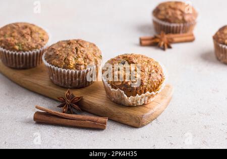 Muffin di zucca appena sfornati fatti in casa con farinata d'avena e noci su sfondo beige Foto Stock