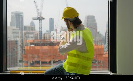 Specialista architetto maschile professionista che parla sul telefono cellulare Foto Stock