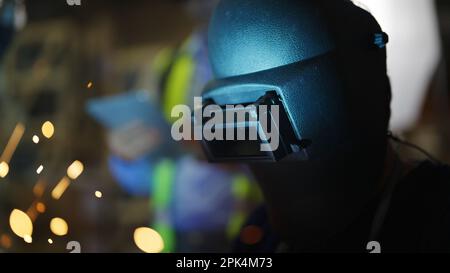 Saldatori saldatura acciaio in fabbrica, saldatori con maschera protettiva Foto Stock