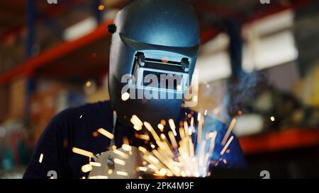 Saldatori saldatura acciaio in fabbrica, saldatori con maschera protettiva Foto Stock