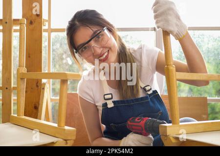 Ritratto di una lavoratrice professionista di carpentiere con un cacciavite elettrico Foto Stock