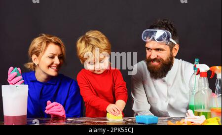 Giorno di pulizia. Pulizia di famiglia insieme. Padre, madre e figlio puliscono casa insieme e si divertono. La famiglia felice pulisce la casa. Pulizia della molla Foto Stock