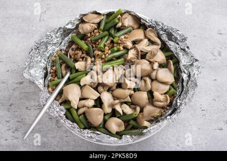 Un semplice piatto vegano al vapore. Grano saraceno con fagioli verdi e funghi di ostriche, vista dall'alto. Delizioso cibo sano fatto in casa Foto Stock