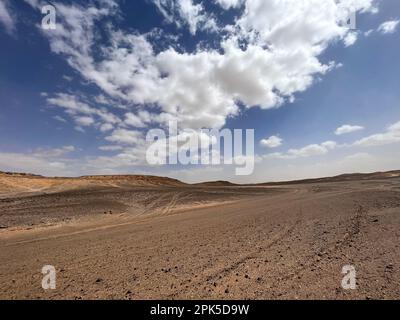 Merzouga, Marocco, Africa: Strada panoramica nel deserto del Sahara nella zona della montagna Nera, con vista sulle pietre nere, i fossili e le dune di sabbia Foto Stock
