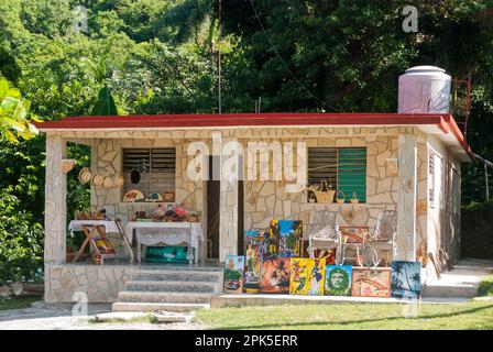 Una casa rurale su un percorso turistico a piedi vicino Jiabacoa Cuba mostra un gran numero di souvenir in vendita nel giardino anteriore. Foto Stock