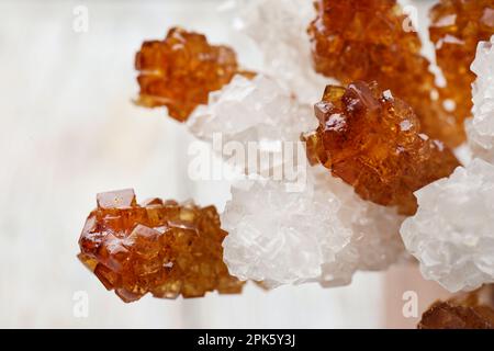 Diversi cristalli di zucchero su sfondo chiaro, primo piano. Gustose caramelle di roccia Foto Stock