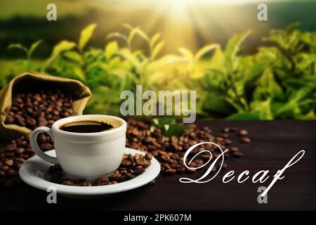 Tazza di caffè decaffeinato aromatico e fagioli su un tavolo di legno all'aperto Foto Stock