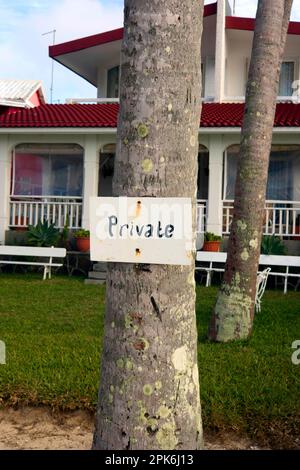 Un segno che dice privato è stato inchiodato ad un tronco dell'albero come suggerimento, Costa orientale, Mauritius Foto Stock