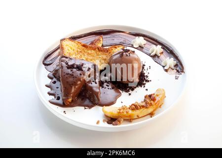 Toast alla francese al cioccolato con una paletta di gelato al cioccolato sul lato e banana tagliata. Foto Stock