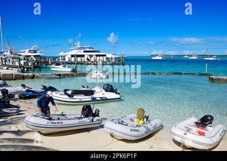 Gommoni sulla spiaggia e yacht a vela nel porto di Staniel Cay, Exuma Cays, Bahamas Foto Stock