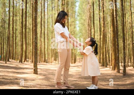 Famiglia felice madre e figlia godendo in foresta insieme Foto Stock