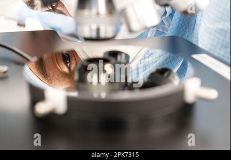 Ulm, Germania. 04th Apr, 2023. I dipendenti di Trumpf photonic Components GmbH siedono in postazioni di lavoro nella produzione di camere bianche dove vengono ispezionati i wafer assemblati con diodi laser VCSEL. Credit: Marijan Murat/dpa/Alamy Live News Foto Stock