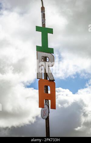 Lettere Spelling I.R.A. è visto in alto su un lampione a Belfast ovest , Irlanda del Nord . Foto Stock