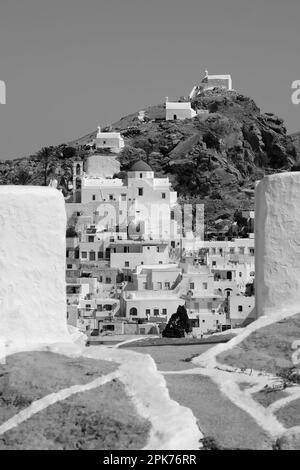Vista panoramica di una chiesa, cappelle più piccole e il villaggio che si affaccia sul Mar Egeo a iOS in Grecia, noto anche come Chora in bianco e nero Foto Stock