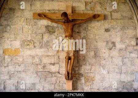 Norwich, Regno Unito, 5, Aprile, 2023 Crocifisso installato nei chiostri della Cattedrale di Norwich. Il corpus (figura di Gesù) è scolpito da legno da artigiani o Foto Stock