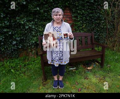 Linda Molloy tiene fotografie di suo figlio John accanto ad una panchina dedicata alla sua memoria al Wave Trauma Centre di Belfast. John è stato ucciso nel nord di Belfast nel 1996 all'età di 18 anni e Linda ha dichiarato di aver votato a favore dell'accordo del Venerdì Santo per la pace per i suoi figli sopravvissuti e i suoi nipoti, ma ha detto che la sua famiglia e altre vittime di problemi sono state lasciate indietro dal processo politico. Data immagine: Mercoledì 5 aprile 2023. Foto Stock