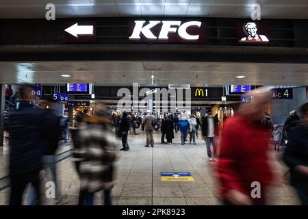 Foto dell'atrio sotterraneo di Koln Hbf con persone che corrono a Colonia, in Germania, passando per un logo del locale KFC fast food. Il KFC è un americano Foto Stock