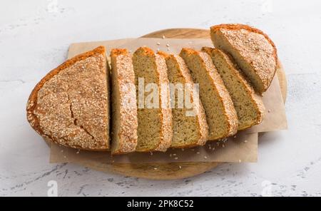 Delizioso pane di lenticchie senza glutine senza farina con semi di sesamo in un piatto da forno bianco su sfondo grigio chiaro, vista dall'alto. vegeto fatto in casa Foto Stock