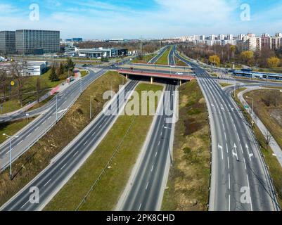 Incrocio multilivello dell'autostrada cittadina a Cracovia, Polonia. Tram e tram, autobus, auto, piste ciclabili e parchi pubblici. Vista aerea Foto Stock