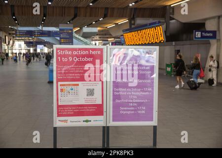 Le persone passano davanti a una bacheca informativa che informa i passeggeri dell'azione industriale alla stazione ferroviaria di London Bridge a Londra. Foto Stock