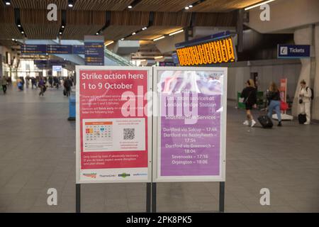 Le persone passano davanti a una bacheca informativa che informa i passeggeri dell'azione industriale alla stazione ferroviaria di London Bridge a Londra. Foto Stock