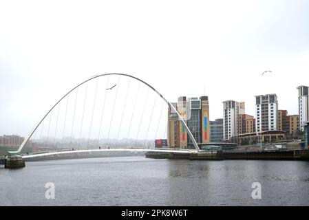 Newcastle upon Tyne, Tyne and Wear, Inghilterra, Regno Unito. Gateshead Millennium Bridge (2001) attraverso il fiume Tyne, Gateshead sulla riva lontana. Giorno di pioggia e grigio Foto Stock