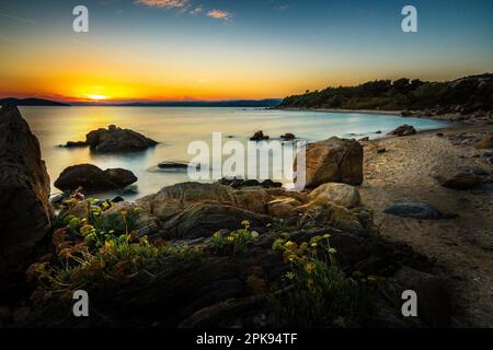 Tramonto sulla spiaggia sabbiosa del villaggio di Ouranoupoli vicino a Salonicco, Grecia Foto Stock