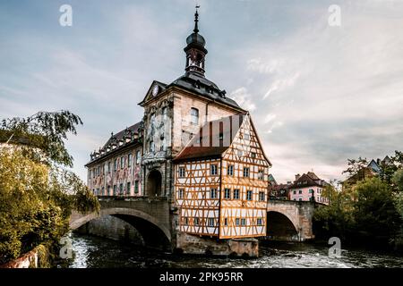 Bamberga, lo storico Brücken Rathaus, edificio a graticcio nel mezzo del fiume Regnitz, al mattino, sorge l'alba in Germania Foto Stock
