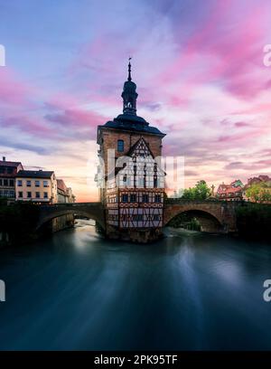 Bamberga, lo storico Brücken Rathaus, edificio a graticcio nel mezzo del fiume Regnitz, al mattino, sorge l'alba in Germania Foto Stock