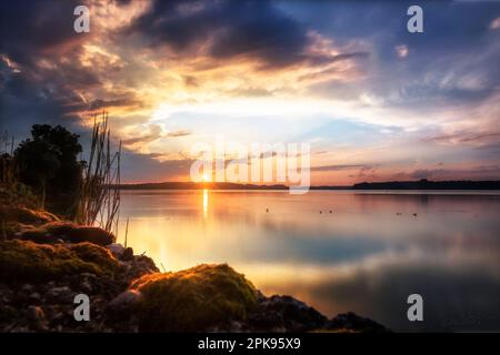 Vista sul lago Chiemsee in Baviera, vicino a Monaco di Baviera, splendido paesaggio girato sul lago al tramonto Foto Stock