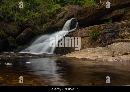 Incredibile cascata nascosta nel profondo delle montagne di Jizera, Repubblica Ceca. Luogo tranquillo e tranquillo con acqua che scorre in cascata fiume. Foto Stock