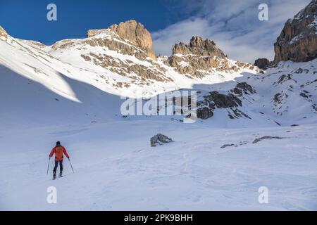 Italia, Trentino Alto Adige / Alto Adige, San Giovanni di Fassa, back country skier (ski alpinista) nella valle del Vaiolet in salita verso il Passo Principe / Grasleitenpass, sopra la cima di Vaiolet / Vajoletspitze e cima piccola di Valbona / Valbonkogel, Catinaccio / Gruppo Rosengarten, Dolomiti Foto Stock