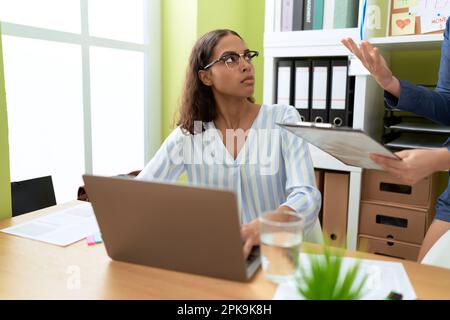 Una giovane donna afroamericana che lavora e si batte in ufficio Foto Stock