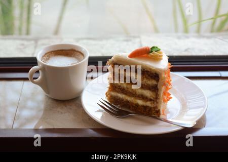 Deliziosa torta e una tazza di caffè caldo al coperto sul davanzale Foto Stock