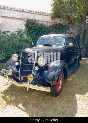 Un vecchio nero antico 1935 Ford V8 coupé cinque finestra modello 48 in un parco. CADEAA 2023 mostra auto classica. Giorno di sole Foto Stock
