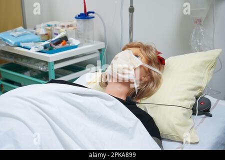 Gli studenti che devono affrontare un'emergenza post-natale seguono le procedure su un manichino. Questo manichino è controllato dagli operatori in una stanza adiacente. Foto Stock