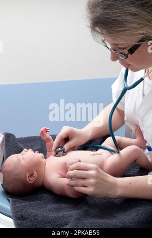 Il pediatra controlla la frequenza cardiaca del neonato. Foto Stock