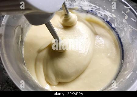 17.01.2023, Germania, , Berlino - la pastella di torta è mescolata in una ciotola con un miscelatore manuale. 00S230117D496CAROEX.JPG [RELEASE DEL MODELLO: NO, RELEASE DELLA PROPRIETÀ: NO ( Foto Stock